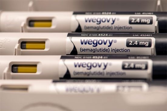 Close-up of Wegovy (semaglutide) injection pens labeled "2.4 mg," with visible yellow medication chambers and white casings.